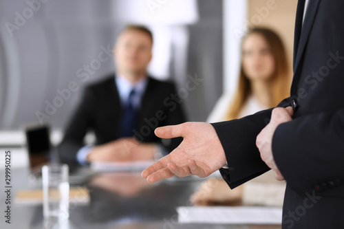 Business presentation. Businessman giving speech to colleagues and partners at corporate meeting or conference, close-up of speaker hands © Iryna