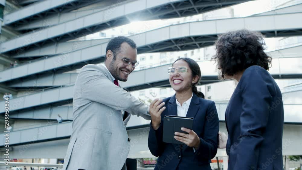 Excited business people using digital tablet. Group of cheerful multiethnic business colleagues in formal wear standing together and using tablet pc. Technology concept Excited business people using digital tablet. Group of cheerful multiethnic business colleagues in formal wear standing together and using tablet pc. Technology concept