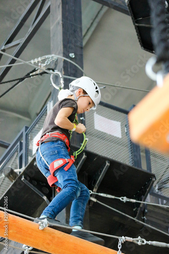 Young boy in the helmet in the adventure rope park close up