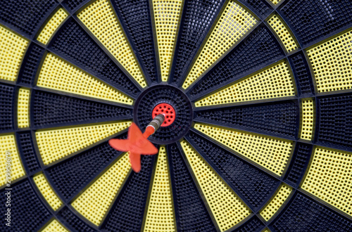 Red arrow hitting target on dart board against blurred green background . Goals concept 