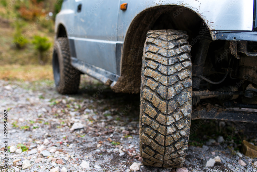 Used cracked off road tire on off road vehicle , forest road close up shot with copy space. Used cracked off road tire on off road vehicle , forest road close up shot with copy space.