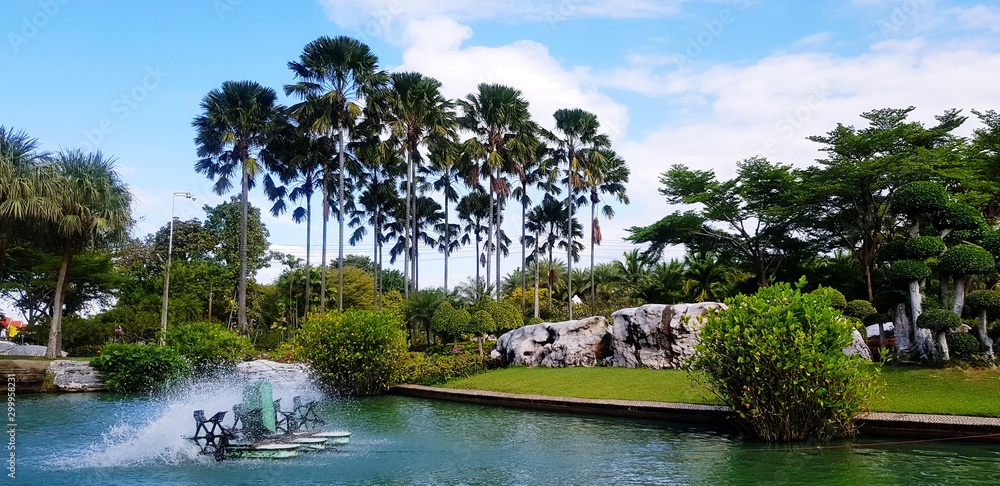 Hydraulic turbine or water vane for increase oxygen and Adjust water balance in lake or pool with coconut, palm, rock and blue sky background at Wat Luang Phor Toh temple, Nakhonratchasim, Thailand. Hydraulic turbine or water vane for increase oxygen and Adjust water balance in lake or pool with coconut, palm, rock and blue sky background at Wat Luang Phor Toh temple, Nakhonratchasim, Thailand.