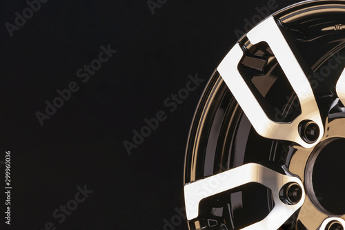 item spokes close-up aluminum die-cast alloy wheel for powerful SUV close-up on black background. polished surface. copyspace left. photo