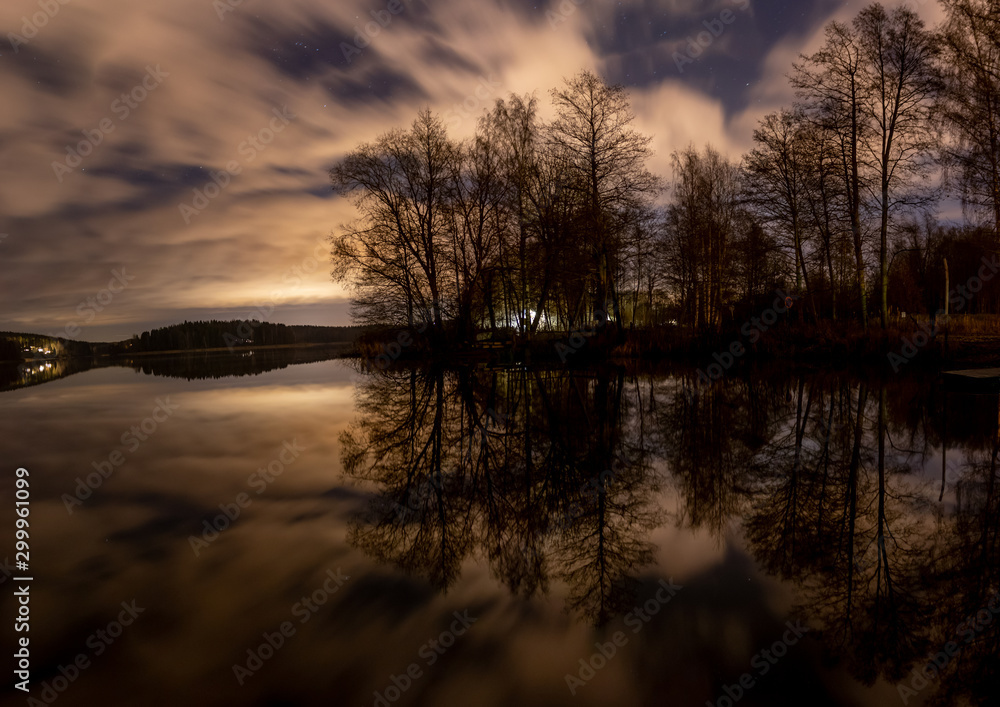 Panoramic long exposure of trees and reflective water at night. Panoramic long exposure of trees and reflective water at night.