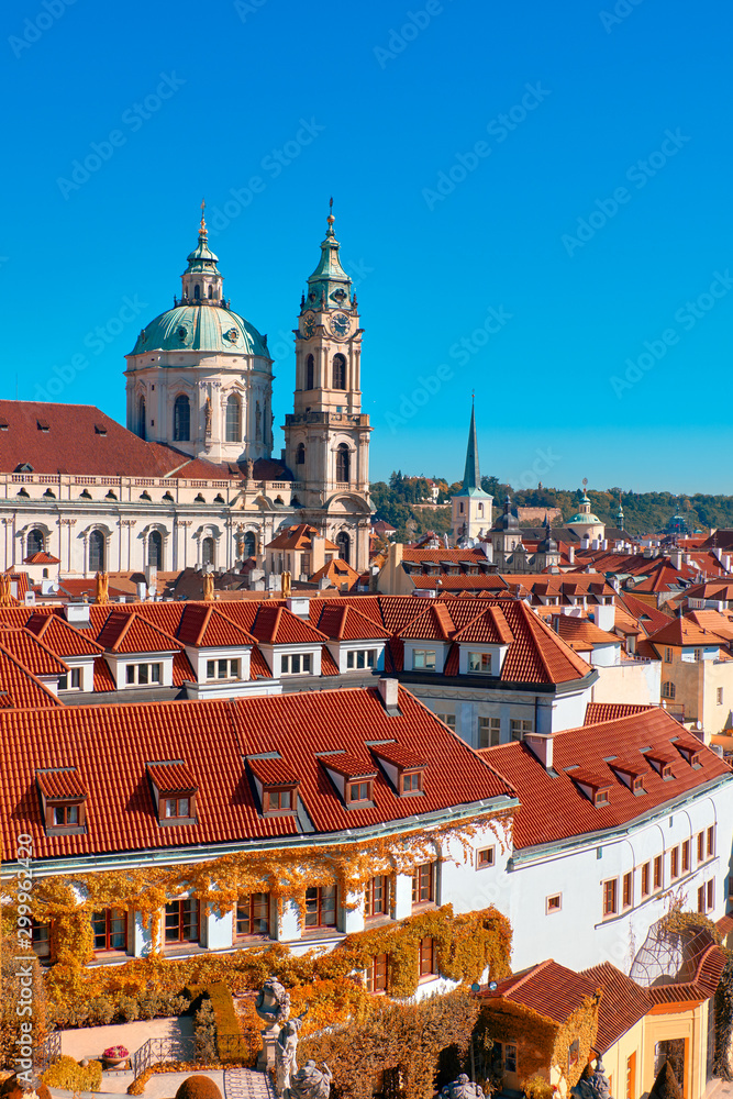 Roofs of old Prague with church of St. Nicolas on a bright Autumn day with blue sky