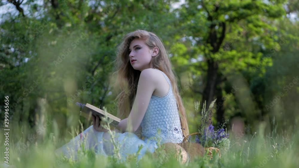 Beautiful young woman reads a book, profile of cute girl sitting under a tree in the forest, concept hobby and lifestyle. Romantic scene. Beautiful young woman reads a book, profile of cute girl sitting under a tree in the forest, concept hobby and lifestyle. Romantic scene.
