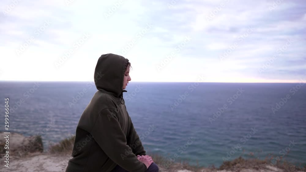 Workout on a rock, attractive slim woman doing stretching in nature over the sea. Wellness training outdoors in sportswear Workout on a rock, attractive slim woman doing stretching in nature over the sea. Wellness training outdoors in sportswear