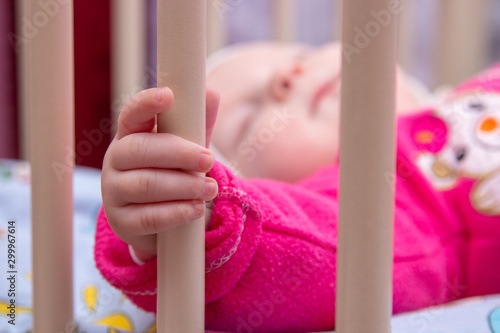 baby hand holding cradle,sleeping baby holding the cradle railing