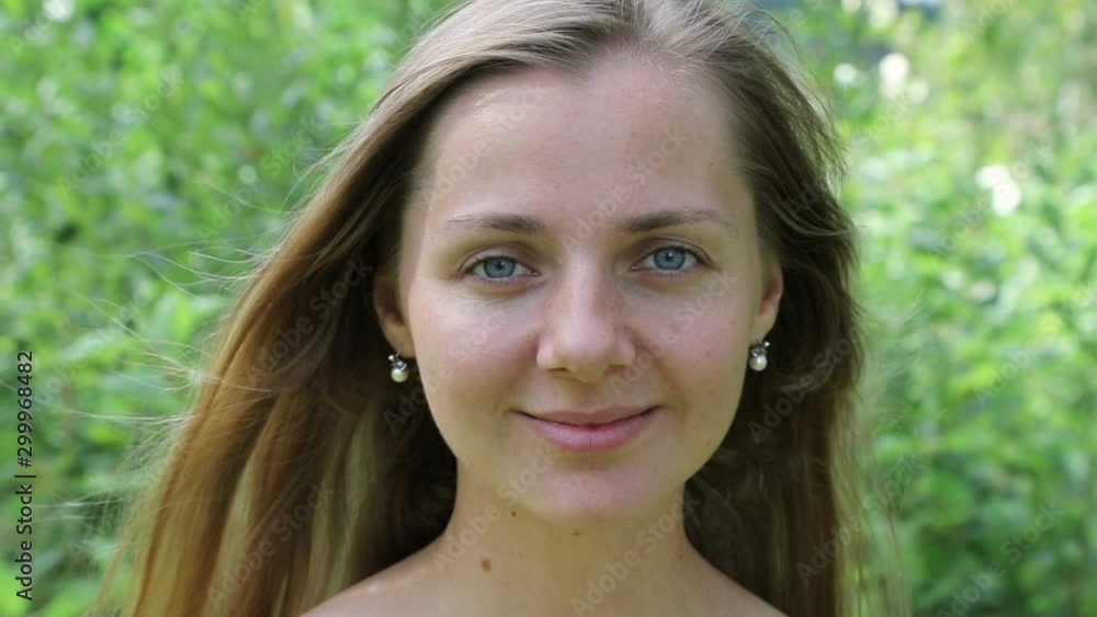 Beautiful caucasian woman smiling sweetly, face close-up. Slow motion. Beautiful caucasian woman smiling sweetly, face close-up. Slow motion.