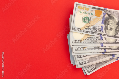 United States or US dollar one hundred banknotes heap of currency on a red background. Money for christmas concept.