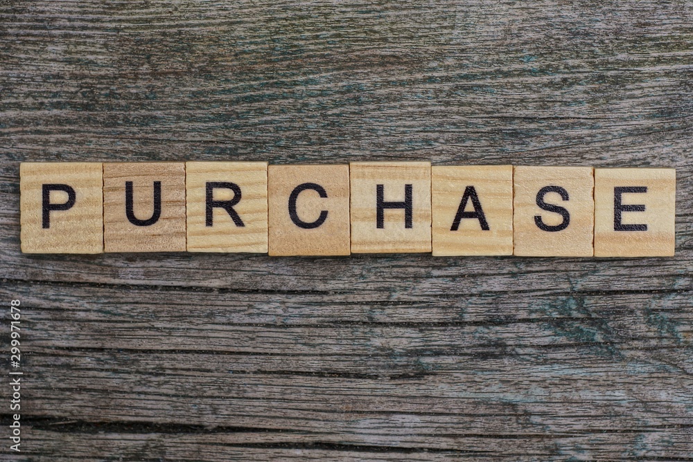 Fototapeta premium purchase word made from brown wooden letters on gray table