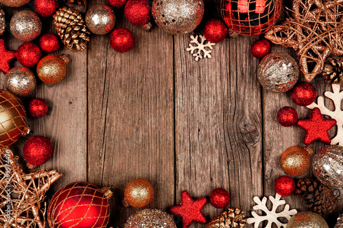 Red and gold Christmas ornament frame. Top view on a rustic wood background.