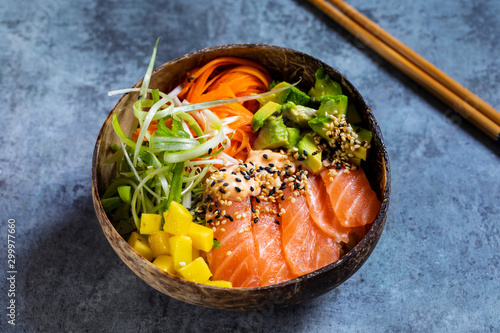 Hawaiian poke bowl with raw salmon, pickled carrots, mango and avocado photo