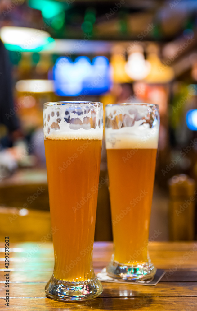 two glass of light beer stands on a table in a bar or pub two glass of light beer stands on a table in a bar or pub