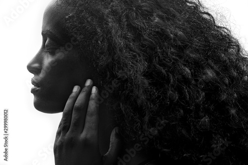 Close up portrait of an attractive dark skinned woman with long hair and strong features, black and white