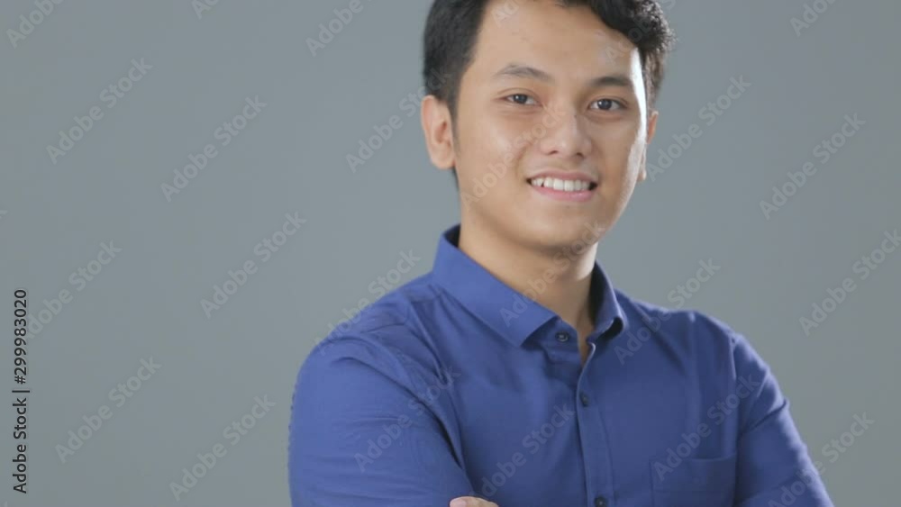 A man with a blue shirt standing looking at the camera A man with a blue shirt standing looking at the camera