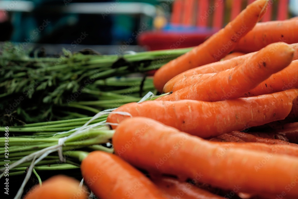 A bunch of fresh washed organic carrot with greens in market A bunch of fresh washed organic carrot with greens in market