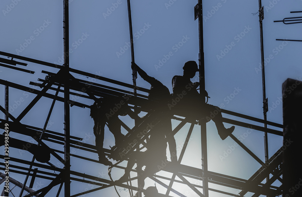 Silhouette City worker, construction crews to work on high ground heavy industry and safety concept over blurred natural background sunset Silhouette City worker, construction crews to work on high ground heavy industry and safety concept over blurred natural background sunset
