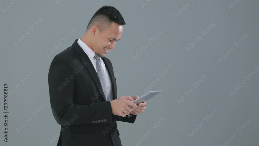 Cheerful young businessman holding his tablet and smile Cheerful young businessman holding his tablet and smile