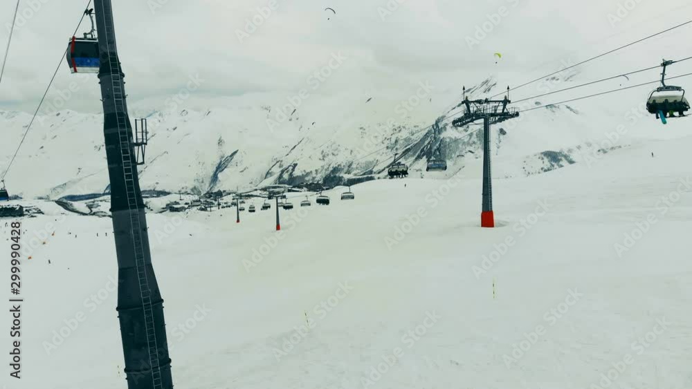 Cable cars are moving along the mountain peaks. Ski lift in the mountains.