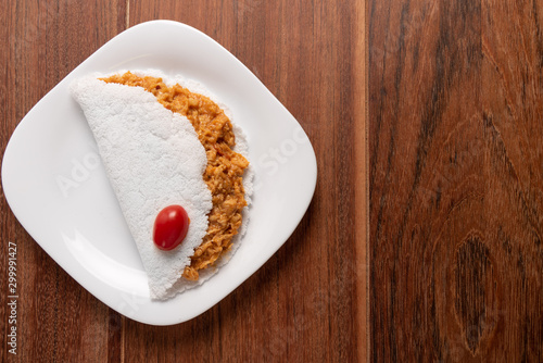 Tapioca filled with chiken breast on wooden background. Flatbread made from cassava (also known as casabe, bammy, beiju, bob, biju). photo