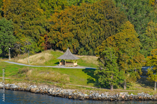 Wooden gazebo on rocky coast in public park at sunny autumn morning. photo