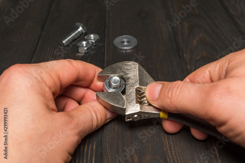 The master tightens the nut with an adjustable wrench