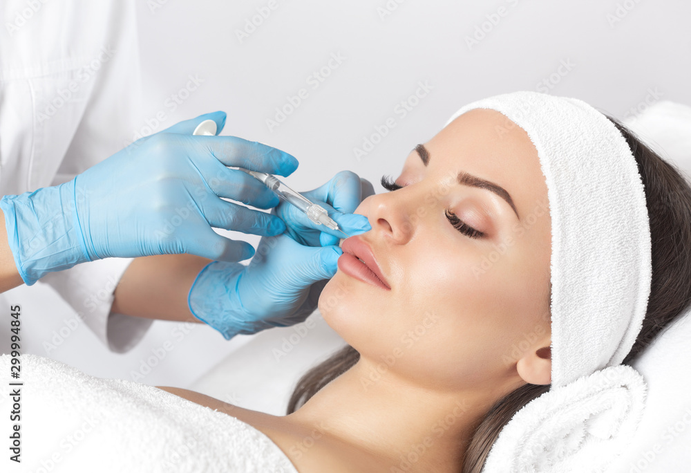Φωτογραφία The doctor cosmetologist makes Lip augmentation procedure of a beautiful woman in a beauty salon