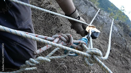 Technique Dulfer. Descent along a fixed rope using a safety device and a gripping unit.