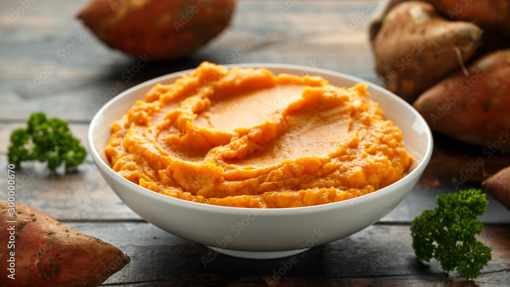 Mashed Sweet Potatoes in white bowl on wooden rustic table. Healthy food Mashed Sweet Potatoes in white bowl on wooden rustic table. Healthy food