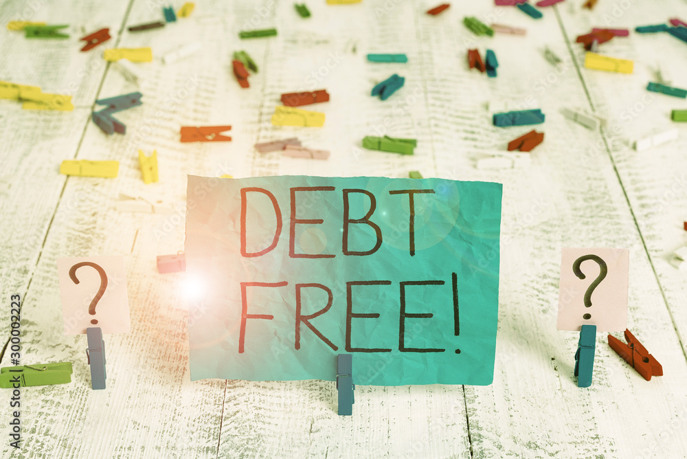 Handwriting text Debt Free. Conceptual photo does not owning any money to any individual or companies Scribbled and crumbling sheet with paper clips placed on the wooden table