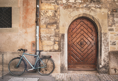 Old meets new. Brick building wall with old vintage wood door and bicycle. Soft light. Town Hall (Rathaus) Luzern, Switzerland © Petra Richli