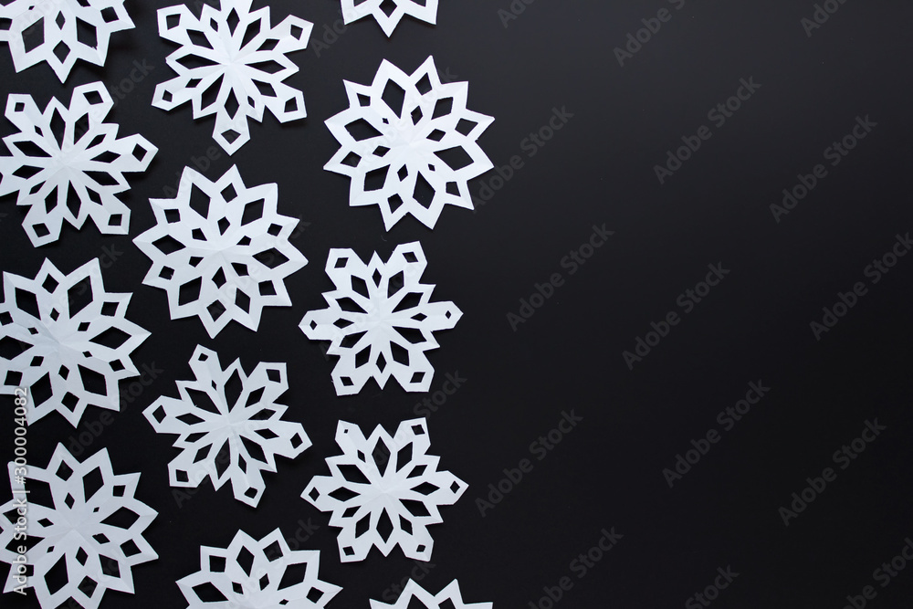 Festive Christmas background with white paper snowflakes