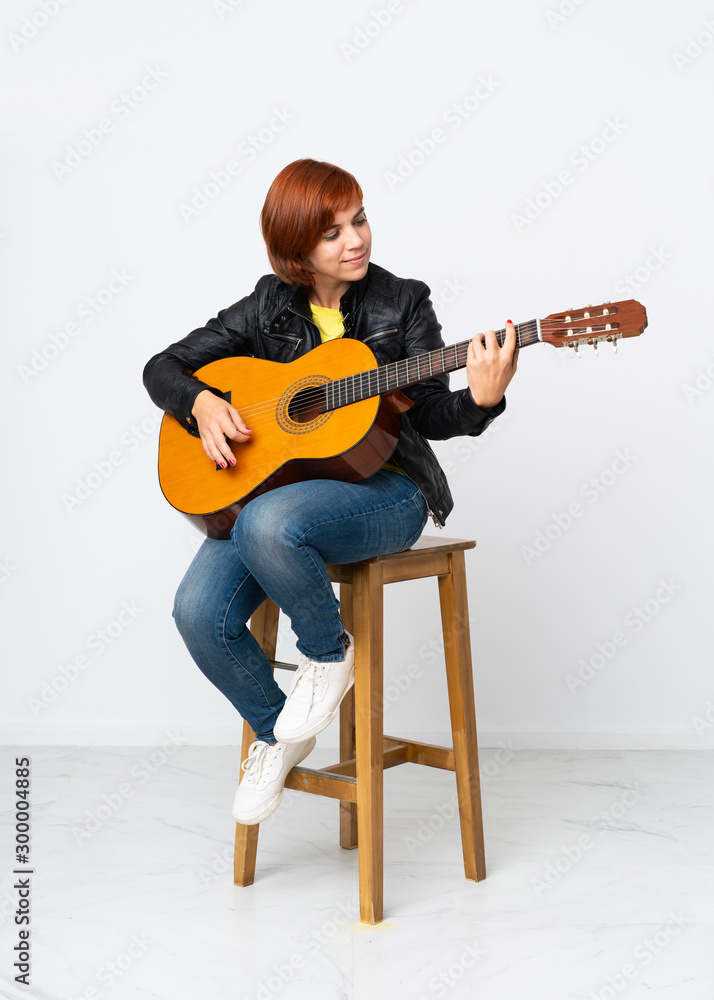 Redhead woman playing guitar