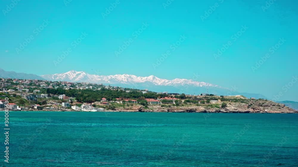 The coast near Rethmynon, Crete with snow capped mountains in the background. Locked down shot The coast near Rethmynon, Crete with snow capped mountains in the background. Locked down shot