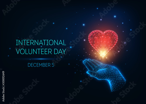 Futuristic glow low poly International Volunteer Day concept with hand holding red heart and text .
