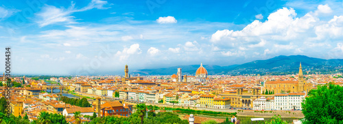 Top aerial panoramic view of Florence city with Duomo Santa Maria del Fiore cathedral, Ponte Vecchio bridge, buildings with orange red tiled roofs, Arno river, blue sky white clouds, Tuscany, Italy © Aliaksandr
