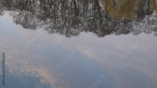 Reflection Of Autumn Forest And White Clouds With Sky In Water Of Lake Slider Shot. photo