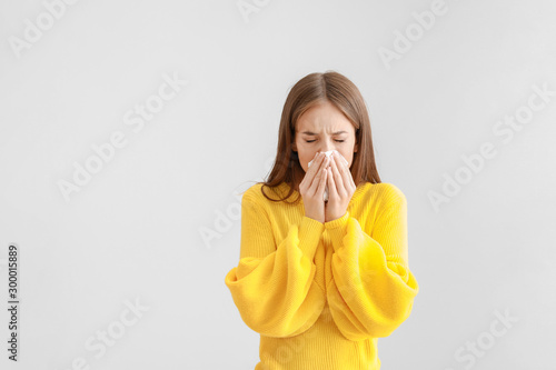 Young woman suffering from allergy on light background Fototapet