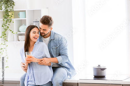Happy young couple in kitch...