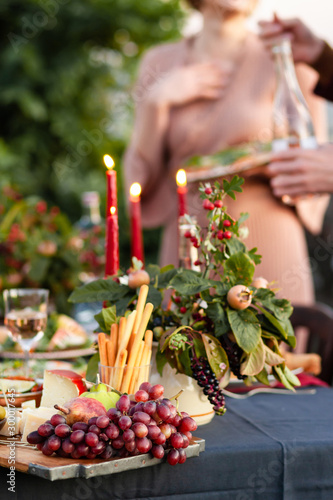 Young couple flirting on a beautifully decorated dinner party. Candles and fresh fruits as decor. Relaxed atmosphere  festive mood