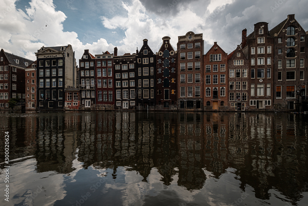 Famous houses in Amsterdam during a moody summer day with reflections (Amsterdam, Netherlands, Europe)