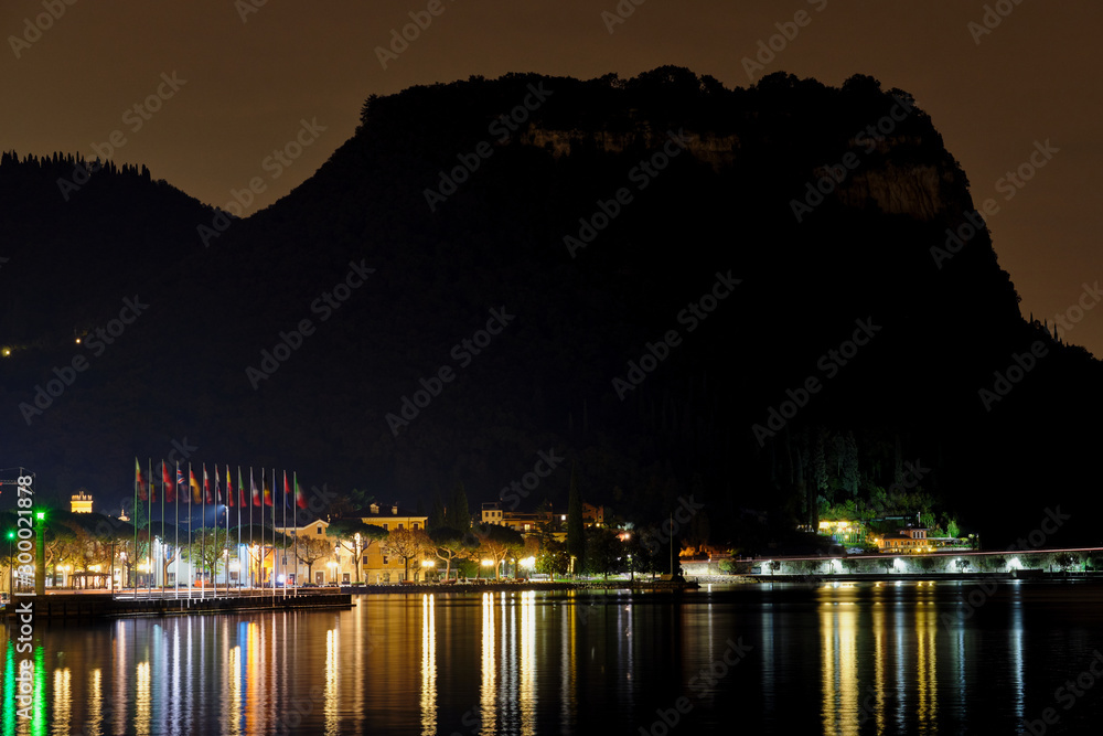 Evening view of the center of Garda, Lake Garda. City night lights reflected in water