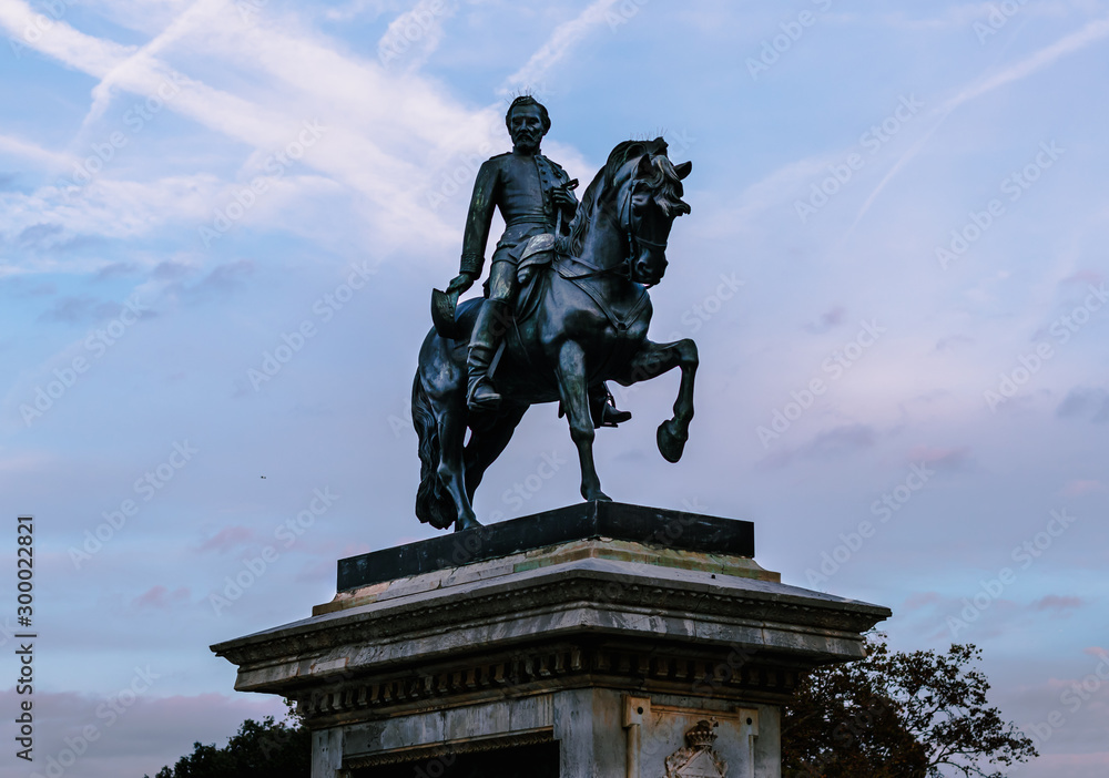 Obraz premium Monumento de un hombre a caballo con cielo de nubes azulado