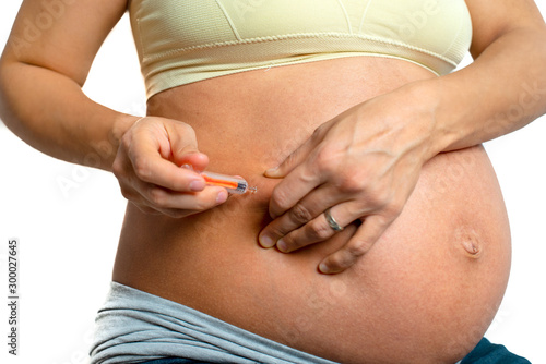Pregnant woman injects anticoagulants into her belly, isolated on white background