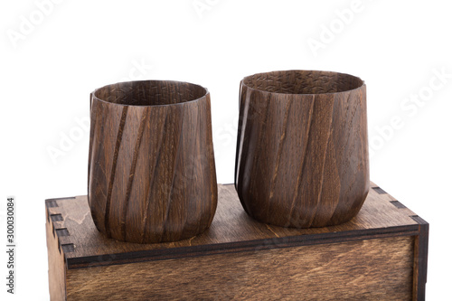 Beautiful wooden mugs on a wooden box. White isolated background.
