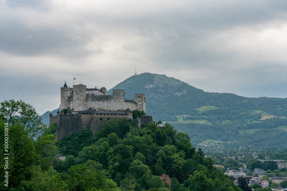 View of the Hohensalzburg fortress and mountains on a cloudy day. Location: Salzburg, Austria.