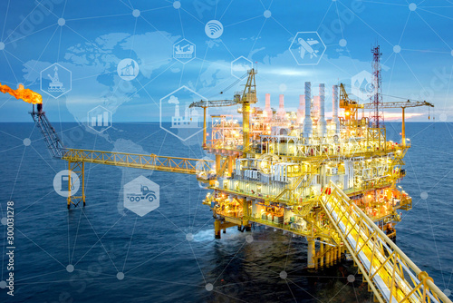 Double exposure   of rig,and icons flow automation and data exchange in manufacturing technologies Industrial offshore oil and gas platform in the gulf ,Industry 4.0 concept image. photo