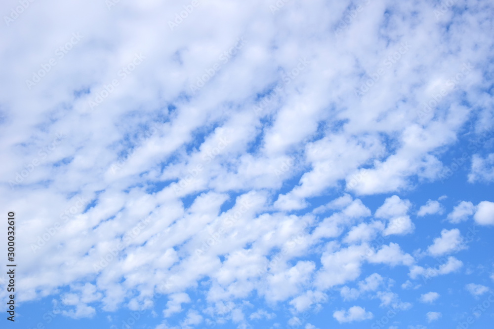 Weiße Schäfchenwolken an einem schönen Sommertag vor blauen Himmel