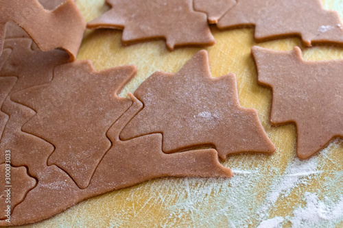 Christmas shaped gingerbread cookie from the raw dough before baking. Process of cutting forms from ginger dough